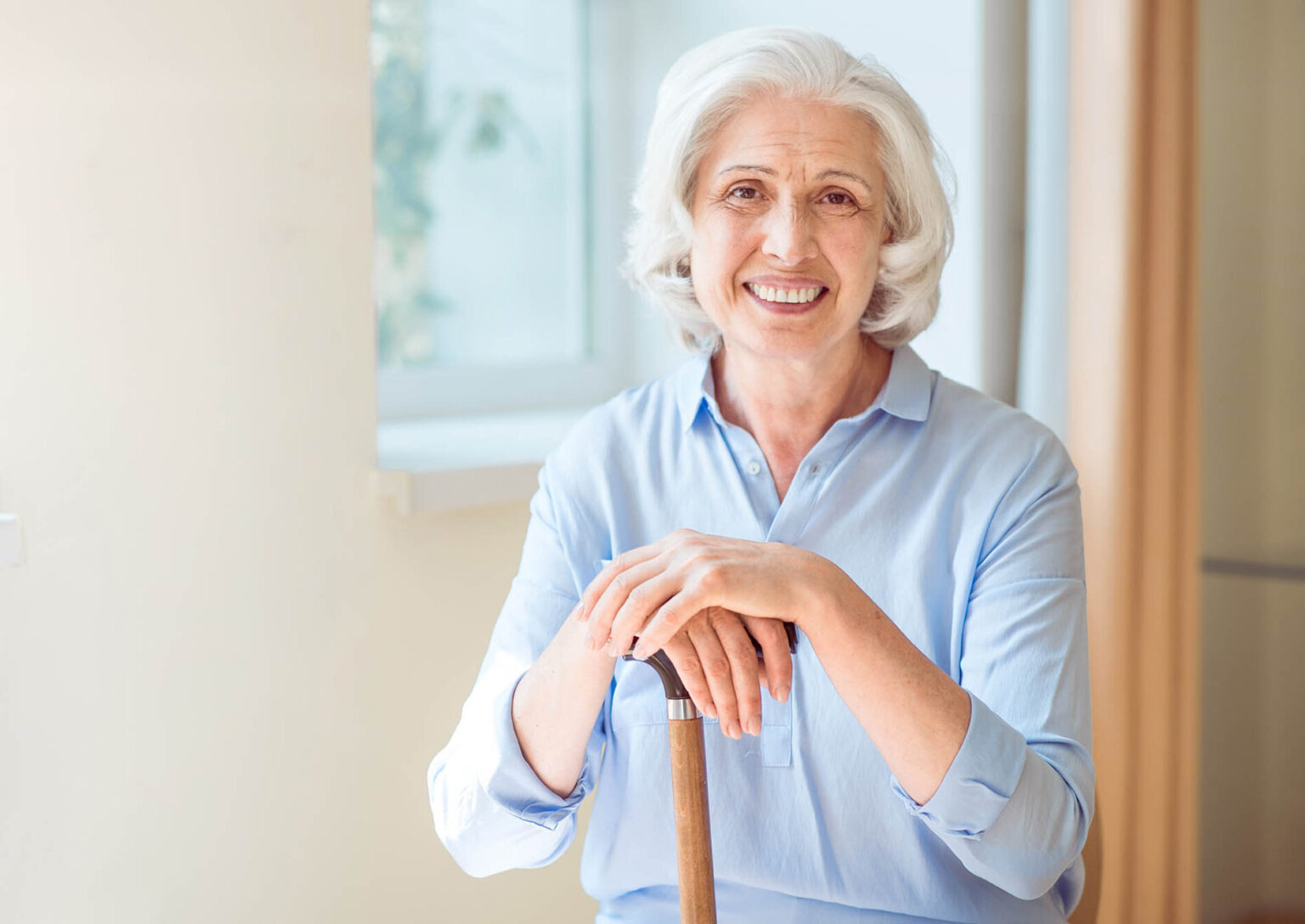 Smiling older woman holding cane